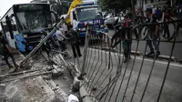 Tiang pembatas jalan yang tumbang seusai dihantam bus gandeng TransJakarta di Jalan Gunung Sahari, Jakarta, Selasa (6/9). Saat ini sopir bus TransJakarta dibawa oleh kepolisian untuk dimintai keterangan perihal kecelakaan itu. (Liputan6.com/Faizal Fanani)