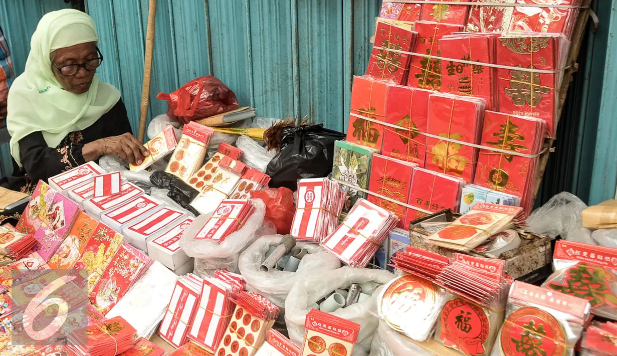 Pedagang angpao menunggu pembeli di kawasan Petak Sembilan, Jakarta, Senin (23/1). Jelang hari raya Imlek 2017 pedagang angpao dan pernak-pernik mulai ramai di kawasan Petak Sembilan. (Liputan6.com/Yoppy Renato)