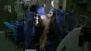 Dokter hewan melakukan operasi terhadap seekor unta di rumah sakit khusus unta di Dubai, Uni Emirat Arab. Peralatan medis di tempat ini dibuat khusus agar bisa digunakan untuk merawat hewan-hewan padang pasir itu. (PATRICK BAZ/DUBAI MEDIA OFFICE/AFP)