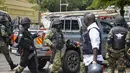 Pasukan keamanan mengamankan lokasi ledakan di sebuah jalan dekat gedung parlemen di Kampala, Uganda (16/11/2021).  Setidaknya ada tiga orang tewas akibat bom tersebut, namun kemungkinan jumlah korban meningkat. (AP Photo/Ronald Kabuubi)
