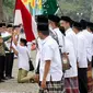 Ketua Umum PBNU Said Aqil Siradj memberikan bendera merah putih kepada santri dalam Upacara Hari Santri Nasional di silang Monas, Jakarta, Sabtu (22/10). (Liputan6.com/Fery Pradolo)