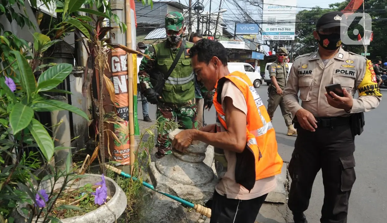 Warga mendapat hukuman kerja sosial saat razia gabungan Kelurahan Gandul di Perempatan Gandul, Cinere, Depok, Kamis ( 29/08/2020). Sebagaimana diketahui Kota Depok saat ini kembali masuk ke dalam wilayah dengan resikobtinggi alias zina merah penularan covid-19 nasional. (merdeka.com/Arie Basuki)