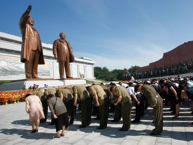 Warga dan tentara memberi penghormatan kepada patung mendiang pemimpin Kim Il Sung dan Kim Jong Il di Bukit Mansu, Pyongyang, Korea Utara, Senin (8/7/2019). Warga Korea Utara tengah memperingati 25 tahun meninggalnya Kim Il Sung. (AP Photo/Jon Chol Jin)