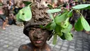 Seorang anak laki-laki Bali ikut serta dalam tradisi mandi lumpur, yang dikenal sebagai Mebuug-buugan, yang diadakan sehari setelah Nyepi - yang bertujuan untuk menetralkan sifat-sifat buruk, di desa Kedonganan, Bali, 12 Maret 2024. (SONNY TUMBELAKA/AFP)