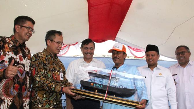 General Manajer Divisi Bisnis Usaha Kecil 2 BNI Bambang Setyatmojo (kedua kiri) menyerahkan miniatur Kapal Latih Nelayan berukuran 5 GT kepada perwakilan nelayan di Desa Ciwaru, Kecamatan Ciemas, Kabupaten Sukabumi, Jawa Barat, Sabtu (20 Juli 2019).