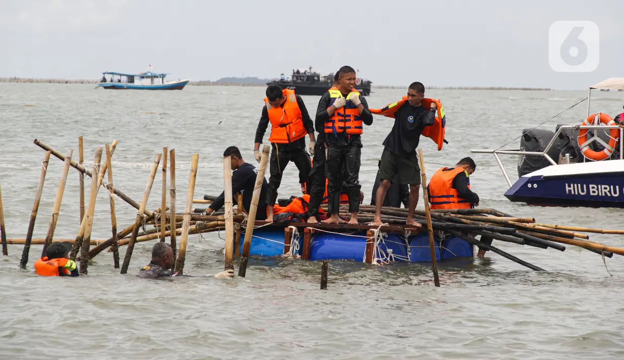 Pagar bambu yang telah copot dikumpulkan lalu langsung dinaikkan ke atas kapal dan dibawa ke dermaga. (Magang/Liputan6.com/Muhammad Rizal)