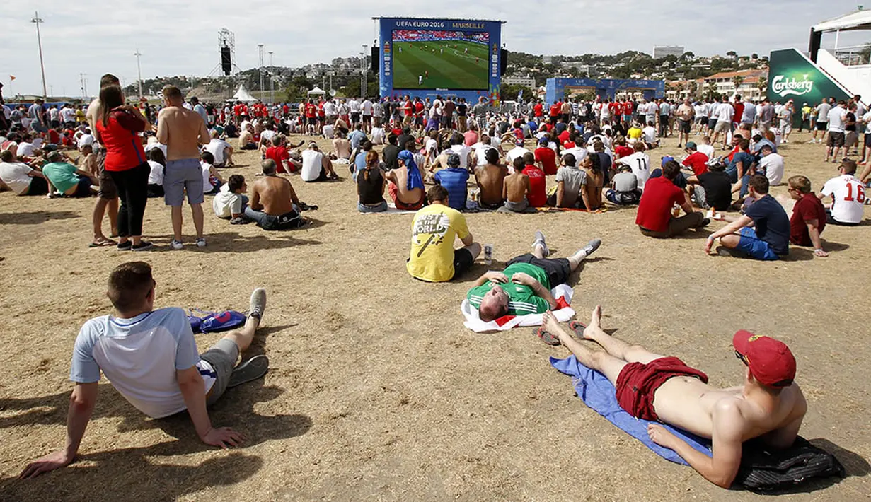 Sejumlah suporter menyaksikan laga Albania melawan Swiss sambil bersantai di area fan zone yang terletak di tepi pantai kawasan Marseille, Prancis, Sabtu (11/6/2016). (AFP/Jean Christophe Magnenet)