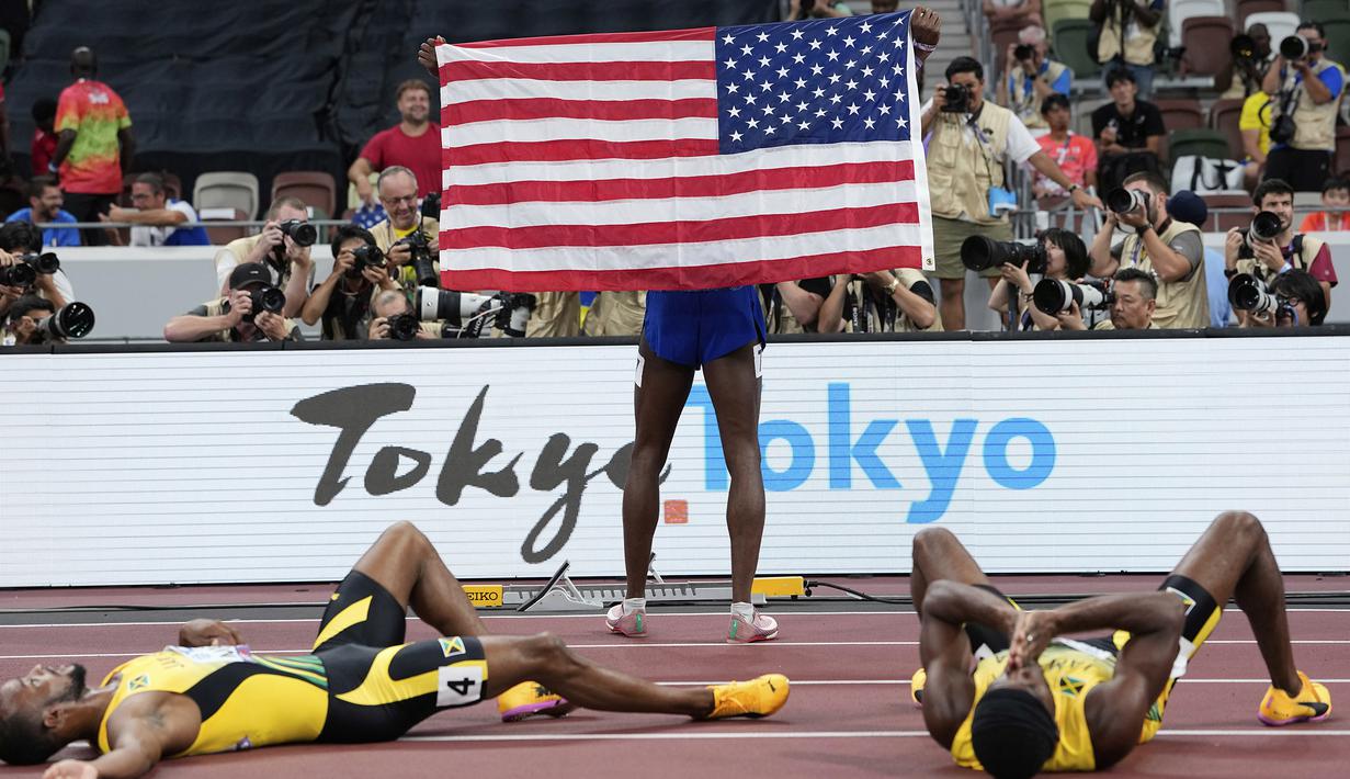 Pelari Amerika Serikat, Cordell Tinch (tengah) berpose di depan fotografer setelah memenangkan final lari gawang 110 meter putra pada Kejuaraan Atletik Dunia di Tokyo, Jepang, Selasa (16/09/2025). (AP Photo/Ashley Landis)