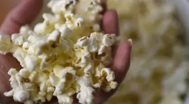 Kandungan karbohidrat dan tryptophan (asam amino) di dalam popcorn dapat menghasilkan hormon serotonin sehingga dapat membuat tubuh menjadi lebih rileks dan lebih mudah untuk tidur. (AFP PHOTO / LOIC VENANCE)