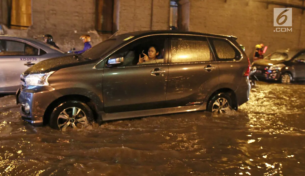 Kendaraan menerobos banjir di terowongan (underpass) Cawang menuju Halim Perdanakusuma, Jalan MT Haryono, Jakarta, Selasa (12/12). Hujan deras yang mengguyur sebagian Jakarta mengakibatkan banjir di kawasan ini. (Liputan6.com/Herman Zakharia)