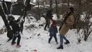 Orang-orang bermain dengan salju saat menghabiskan akhir pekan mereka di sebuah taman di Teheran utara, Iran, Jumat (25/12/2020). Iran berjuang melawan virus corona sangat terhambat oleh sanksi AS yang dijatuhkan pemerintahan Donald Trump. (AP Photo/Vahid Salemi)