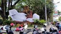 Aremania menutup dua patung singa dan menyisakan satu patung saja dalam aksi yang digelar di depan Stasiun Kota Baru Malang, Senin (16/11/2020). (Bola.com/Iwan Setiawan)