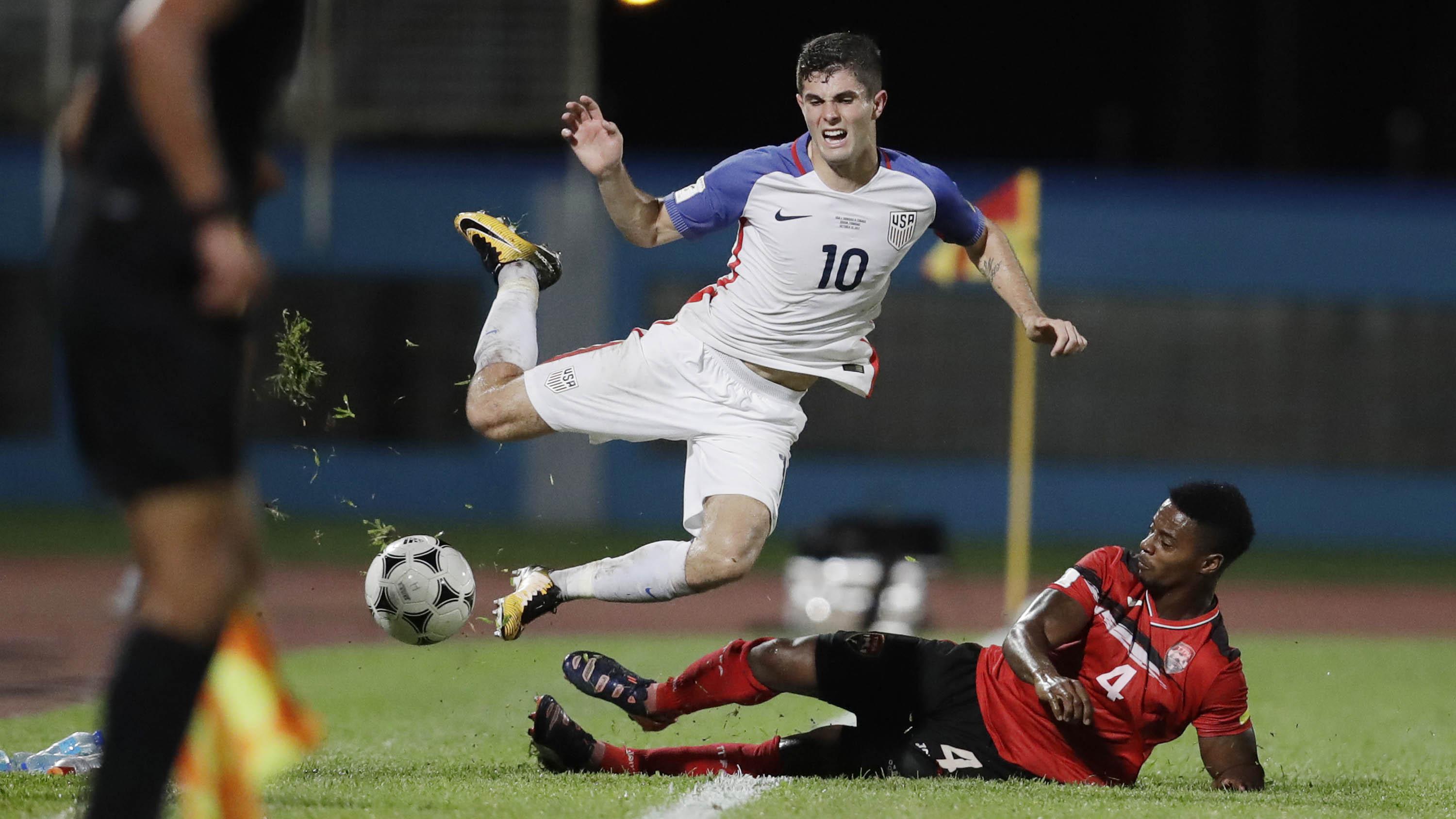 Gelandang Amerika Serikat, Christian Pulisic, terjatuh saat dilanggar pemain Trinidad Tobago pada laga kualifikasi Piala Dunia di Stadion Ato Boldon, Selasa (10/10/2017). Trinidad dan Tobago menang 2-1 atas Amerika Serikat. (AP/Rebecca Blackwell)