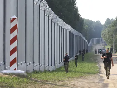 Penjaga perbatasan Polandia berpatroli di area tembok baja yang baru dibangun di perbatasan antara Polandia dan Belarusia, dekat Kuznice, Kamis (30/6/2022). Perdana Menteri Polandia Mateusz Morawiecki mengunjungi daerah perbatasan untuk menandai selesainya pembangunan tembok baja baru. (AP Photo/Michal Dyjuk)