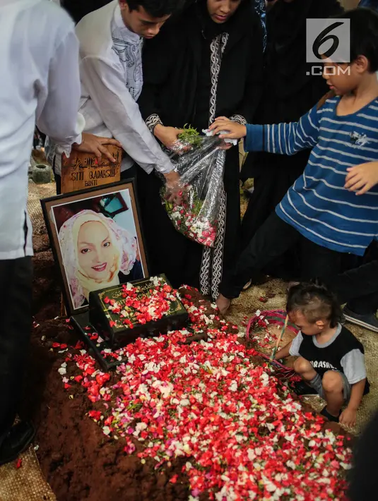 Cucu aktris senior Titi Qadarsih menaburkan bunga di pusara sang nenek saat pemakaman di TPU Tanah Kusir, Jakarta, Selasa (23/10). Wanita yang dapat gelar artis serba bisa itu dianggap legendaris di industri hiburan Tanah Air. (Liputan6.com/FaizalFanani)
