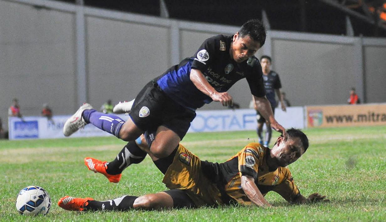 Striker Arema Cronus, Samsul Arif, ditekel pemain Mitra Kukar, Michael Orah pada laga leg pertama semifinal Piala Jenderal Sudirman. (Bola.com/Kevin Setiawan)