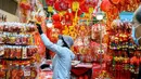 Seorang penjual menata pajangan dekorasi di kios pinggir jalannya yang menjual dekorasi di Hong Kong  (14/1/2021). Menjelang Tahun Baru Imlek, tahun ini menandai Tahun Sapi, yang jatuh pada 12 Februari. (AFP/Anthony Wallace)