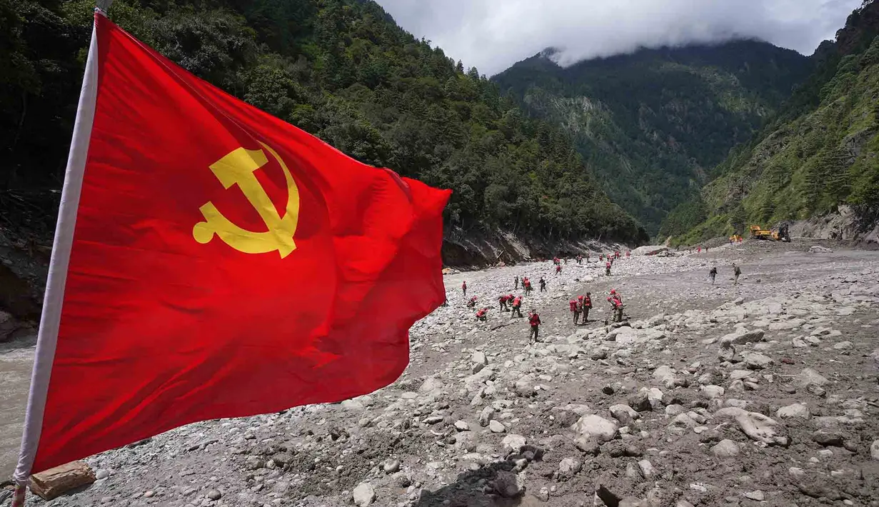 Bendera Partai Komunis berkibar saat polisi paramiliter melakukan operasi pencarian dan penyelamatan di dekat Pelabuhan Gyirong yang rusak akibat tanah longsor dua hari sebelumnya di Kabupaten Gyirong, wilayah Tibet di Tiongkok bagian barat, Sabtu, 29 Agustus 2026. (AFP/ CNS)