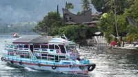 Gambar pada 3 April 2019 menunjukkan sebuah kapal wisata tiba di Pulau Samosir, pulau vulkanik di tengah Danau Toba, provinsi Sumatera Utara, 3 April 2019. Di kalangan masyarakat Batak sendiri, Danau Toba ibaratnya inang atau ibu yang akan selalu menanti dengan keindahannya. (GOH CHAI HIN / AFP)