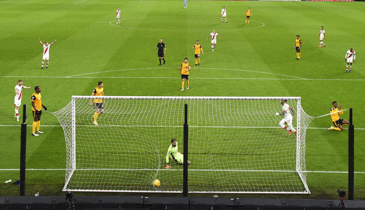Pemain Southampton Theo Walcott mencetak gol ke gawang Wolverhampton Wanderers pada pertandingan Liga Primer Inggris di Molineux Stadium, Wolverhampton, Inggris, Senin (23/11/2020). Pertandingan berakhir 1-1. (Oli Scarff, Pool via AP)