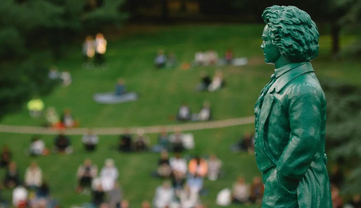 Warga menikmati konser yang diselenggarakan oleh Beethoven Orchestra Bonn di sebuah taman di Bonn, Jerman, pada 28 Juni 2020. Konser tu digelar untuk memperingati 250 tahun kelahiran komponis sekaligus pianis Ludwig van Beethoven. (Xinhua/Tang Ying)