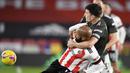 Bek Manchester United, Harry Maguire (kanan), menempel ketat striker Shefffield United, David McGoldrick, dalam laga lanjutan Liga Inggris pekan ke-13 di Bramall Lane, Sheffield, Kamis (17/12/2020). Manchester United menang 3-2 atas Sheffield United. (AFP/Peter Powell/Pool)