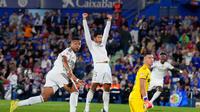 Kylian Mbappe dari Real Madrid, kiri, memperhatikan bola setelah mencetak gol dalam pertandingan sepak bola La Liga antara Getafe dan Real Madrid di Getafe, Spanyol, Minggu, 19 Oktober 2025. (Foto AP/Manu Fernandez)