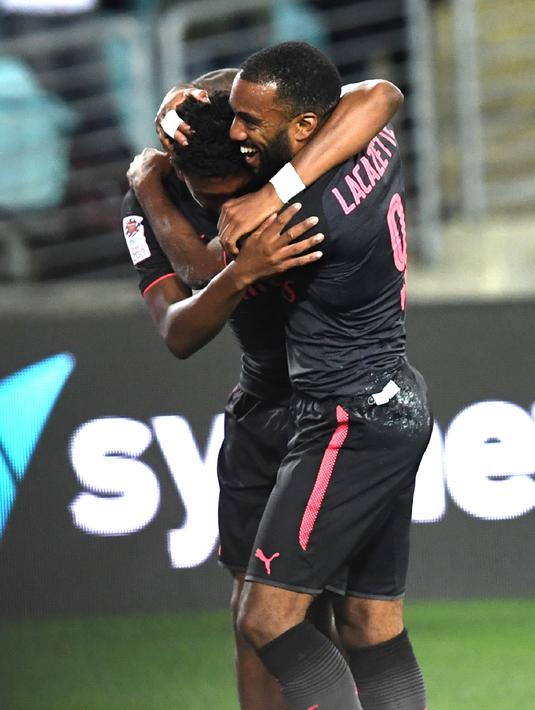 Alexandre Lacazette melakukan selebrasi bersama Alex Iwobi usai mencetak gol ke gawang Sydney FC pada pertandingan persahabatan di Sydney (13/7). Lacazette dibeli 46,5 juta poundsterling dari Olympique Lyon pada 5 Juli 2017. (AFP Photo/William West)