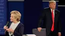 Tingkah aneh Donald Trump pada saat rivalnya, Hillary Clinton memaparkan pendapatnya selama debat Capres AS putaran kedua di Washington University, St Louis, AS, Minggu (9/10). (AP Photo/Julio Cortez)