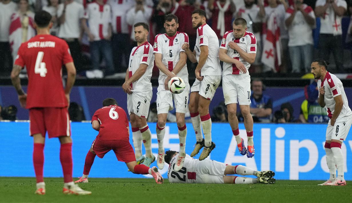 Para pemain Timnas Georgia berusaha memblok bola tendangan bebas dari pemain Timnas Turki pada laga matchday pertama Grup F Euro 2024 di Westfalenstadion, Dortmund, Jerman, Selasa (18/6/2024). (AP Photo/Martin Meissner)