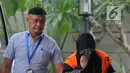Anggota DPRD Kota Malang Een Ambarsari (kanan) menutupi wajah saat tiba di Gedung KPK, Jakarta, Selasa (2/10). Een menjalani pemeriksaan terkait dugaan menerima suap pembahasan APBD-P Pemkot Malang Tahun Anggaran 2015. (Merdeka.com/Dwi Narwoko)