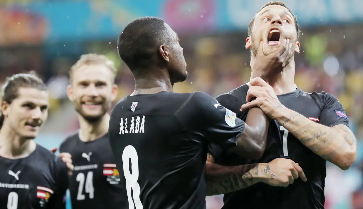 Kapten Austria, David Alaba, meremas mulut Marko Arnautovic saat merayakan gol ke gawang Makedonia Utara. Aksi itu dilakukan Alaba karena rekannya tersebut terindikasi melakukan Selebrasi Berbau Rasis. (Robert Ghement/Pool via AP)