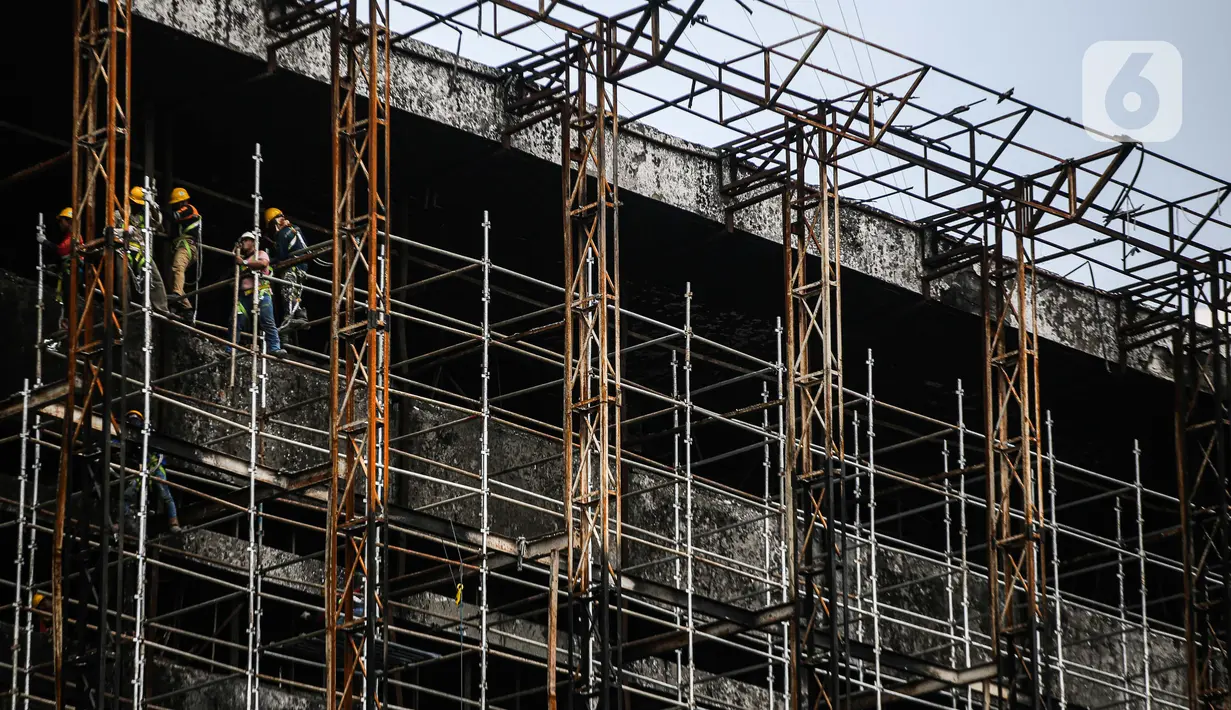 Pekerja memasang 'scaffolding' atau struktur besi untuk melakukan perbaikan Gedung Kejaksaan Agung, Jakarta, yang hangus terbakar, Rabu (7/10/2020).  DPR RI menyepakati penambahan anggaran Kejagung sebesar Rp 350 miliar untuk merenovasi gedung utama yang terbakar hebat. (Liputan6.com/Faizal Fanani)