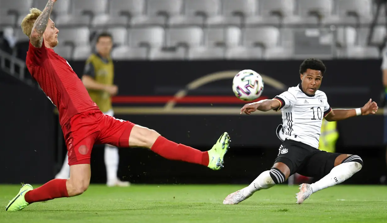 Pemain Denmark Simon Kjaer (kiri) berebut bola dengan pemain Jerman Serge Gnabry (kanan) pada pertandingan persahabatan di Tivoli Stadion Tirol, Innsbruck, Austria, Rabu (2/6/2021). Pertandingan berakhir dengan skor 1-1. (AP Photo/Andreas Schaad)