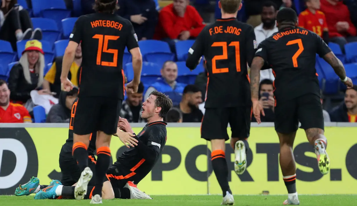 <p>Striker Belanda Wout Weghorst (tengah) merayakan dengan rekan setimnya setelah mencetak gol ke gawang Wales selama pertandingan grup A4 UEFA Nations League di stadion Cardiff City di Cardiff, Wales selatan, Kamis (9/6/2022). Belanda menang tipis atas Wales 2-1. (AFP/Geoff Caddick)</p>