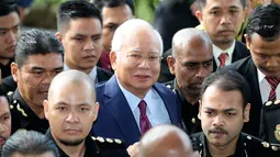 Mantan Perdana Menteri Malaysia, Najib Razak tiba untuk menjalani sidang dakwaan di Pengadilan Kuala Lumpur, Rabu (4/7). Kerumunan media yang menunggu juga warga yang penasaran dengan kasus Najib berdesakan mengambil gambarnya. (AP/Vincent Thian)