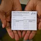 Warga Amerika Serikat menunjukkan kartu vaksin setelah ia divaksinasi di Los Angeles. (dok. Robyn Beck / AFP)