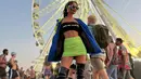 Nonton Coachella, Erika Carlina tampil festive dengan memadukan outfit neon dan hitam. Ia mengenakan strapless top dari Alexander Wang yang dipadukan dengan rok mini neon. Penampilan Erika ditutup jaket dan high tight boots (instagram/eri.carl)