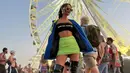 Nonton Coachella, Erika Carlina tampil festive dengan memadukan outfit neon dan hitam. Ia mengenakan strapless top dari Alexander Wang yang dipadukan dengan rok mini neon. Penampilan Erika ditutup jaket dan high tight boots (instagram/eri.carl)