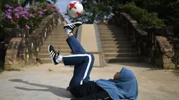 Aksi Qhouirunnisa Endang Wahyudi saat men-juggling bola di sebuah taman di Klang, Kuala Lumpur, (11/7). (AFP Photo/Mohd Rasfan)