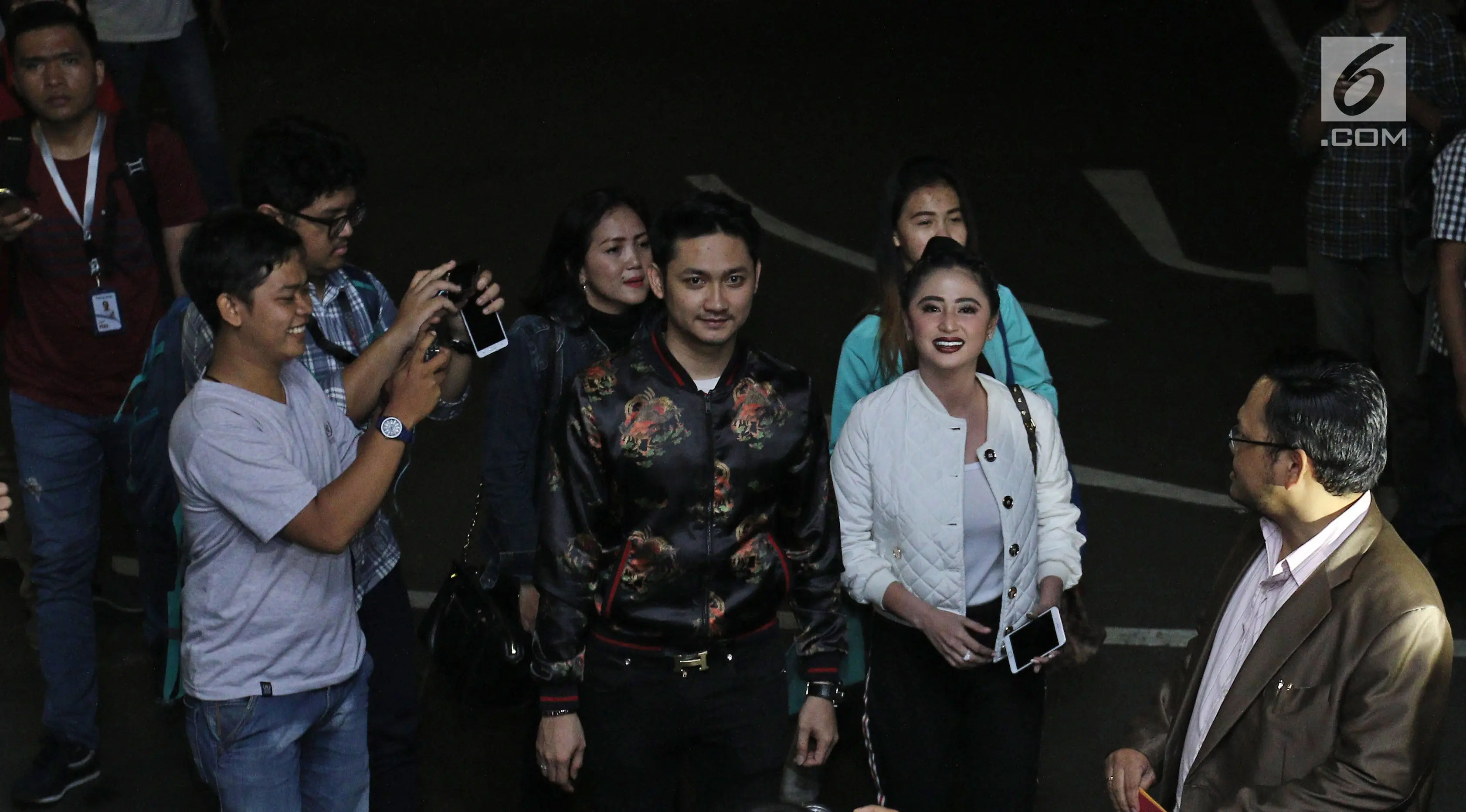 	Pedangdut Dewi Persik didampingi suaminya, Angga Wijaya serta pengacara tiba di Polda Metro Jaya, Jakarta, Senin (4/12). Pihak pedangdut Dewi Perssik resmi melaporkan balik petugas Transjakarta bernama Harry Maulana Saputra. (Liputan6.com/Herman Zakharia)