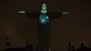 Patung Christ the Redeemer bermandi cahaya gambar bumi di Rio de Janeiro, Brasil, Rabu (18/3/2020). Pertunjukan ini untuk menunjukkan dukungan bagi mereka yang menderita virus corona COVID-19. (AP Photo/Silvia Izquierdo)