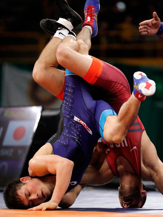 Yuki Takahashi dari Jepang (kiri) saat bertanding melawan Thomas Gilman dari Amerika Serikat selama pertandingan gulat 57 kilogram di Freestyle Wrestling World Cup di Iowa City, Iowa (8/4). (AP Photo/Charlie Neibergall)