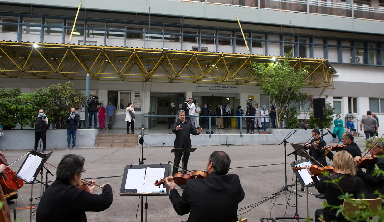 Para anggota ERT (Hellenic Broadcasting Corporation) Modern Music Orchestra memainkan musik di halaman Rumah Sakit Umum Evaggelismos di Athena, Yunani (20/4/2020). Konser digelar oleh ERT Modern Music Orchestra untuk menghormati staf medis dalam perjuangan melawan COVID-19. (Xinhua/Marios Lolos)