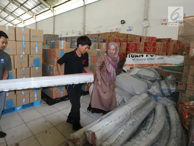Manager Corporate Affairs JICT Indira Lestari (kanan) menyerahkan bantuan 4 tenda darurat kepada tim ACT di Gudang IHC-ACT Parung, Bogor, Jumat (12/10). Bantuan diperuntukkan kepada korban gempa dan tsunami di Palu dan Donggala. (Liputan6.com/HO/Arif)