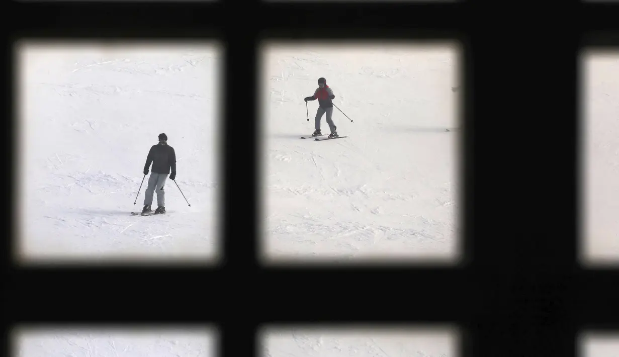 Pemain ski menuruni lereng di resor ski Tochal di luar ibu kota Teheran, Iran (1/1/2022). Di tengah polusi udara dan kesengsaraan ekonomi, penduduk Teheran menemukan kenyamanan di resor ski di utara Teheran di pegunungan Alborz. (AP Photo/Vahid Salemi)