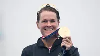 Atlet Flora Duffy dari Bermuda berpose dengan medali emasnya di podium setelah memenangkan kompetisi triathlon individu putri Olimpiade Tokyo 2020 di Odaiba Marine Park, Tokyo, Jepang, Selasa, 27 Juli 2021. (Loic VENANCE / AFP)