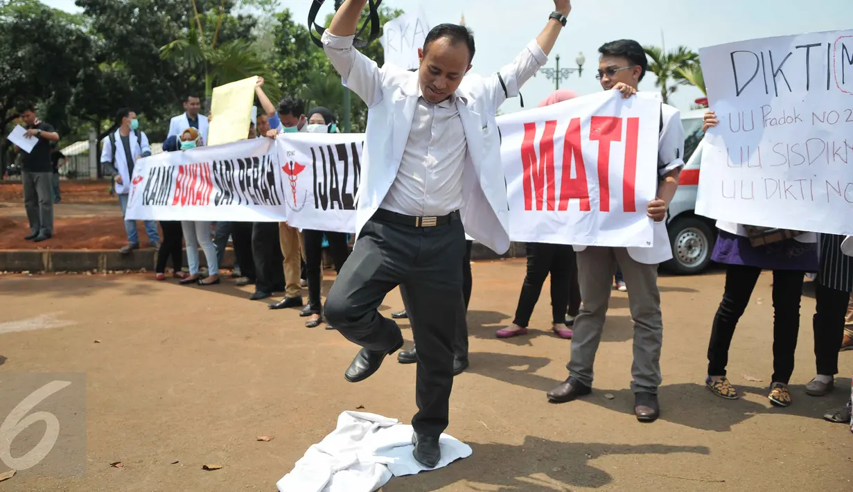 Massa menginjak jas putih khas dokter saat melakukan unjuk rasa di depan Istana Merdeka, Jakarta, Senin (7/9/2015). Mereka memprotes Kemenristek Dikti yang telah menahan ijazah fakultas kedokteran mereka. (Liputan6.com/Gempur M Surya)