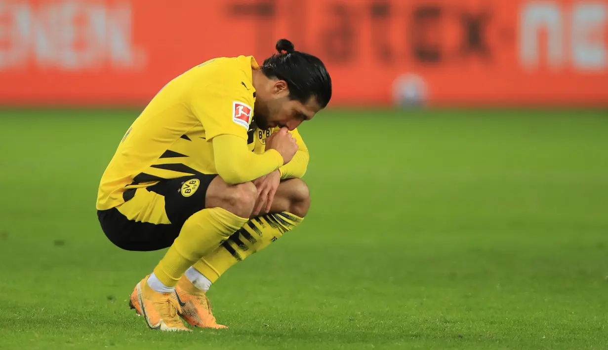 Gelandang Borussia Dortmund, Emre Can tertunduk kecewa usai dikalahkan Borussia Moenchengladbach 2-4 dalam laga lanjutan Liga Jerman 2020/21 pekan ke-18 di Borussia Park, Jumat (22/1/2021). (AFP/Wolfgang Rattay/Pool)