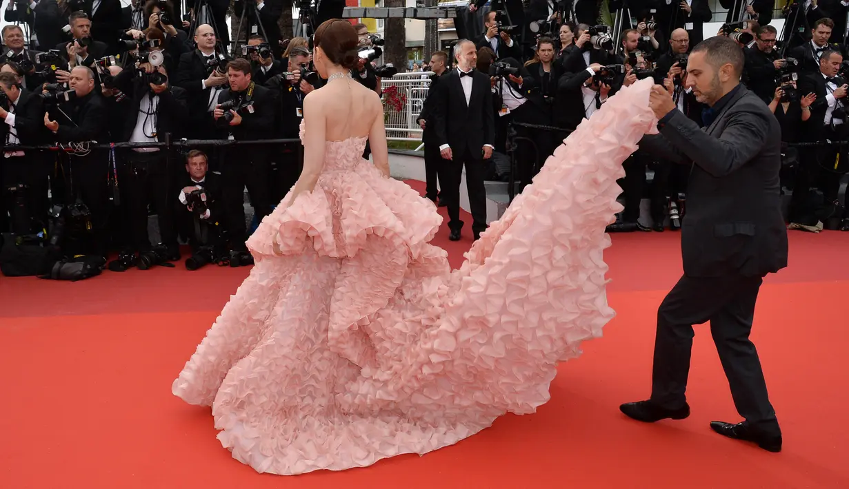 Asisten Araya Hargate merapikan kostum sang aktris sebelum berpose di karpet merah, saat tiba dalam pembukaan dan screening film "Cafe Society" pada kompetisi Film Cannes ke-69 dalam Festival Film Cannes di Prancis, Rabu (11/5/2016). (Alberto PIZZOLI/AFP)